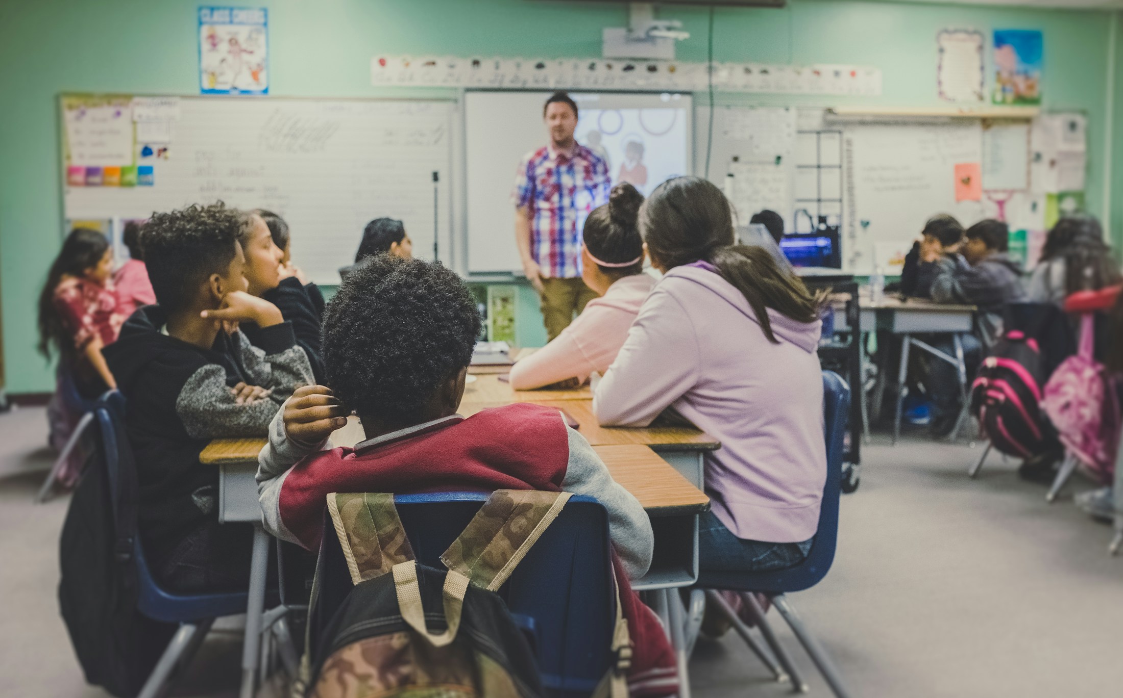 A teacher and students discussing their work in class